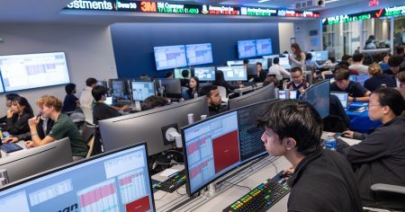Traders working together on a connected trading floor with multiple market-data monitors